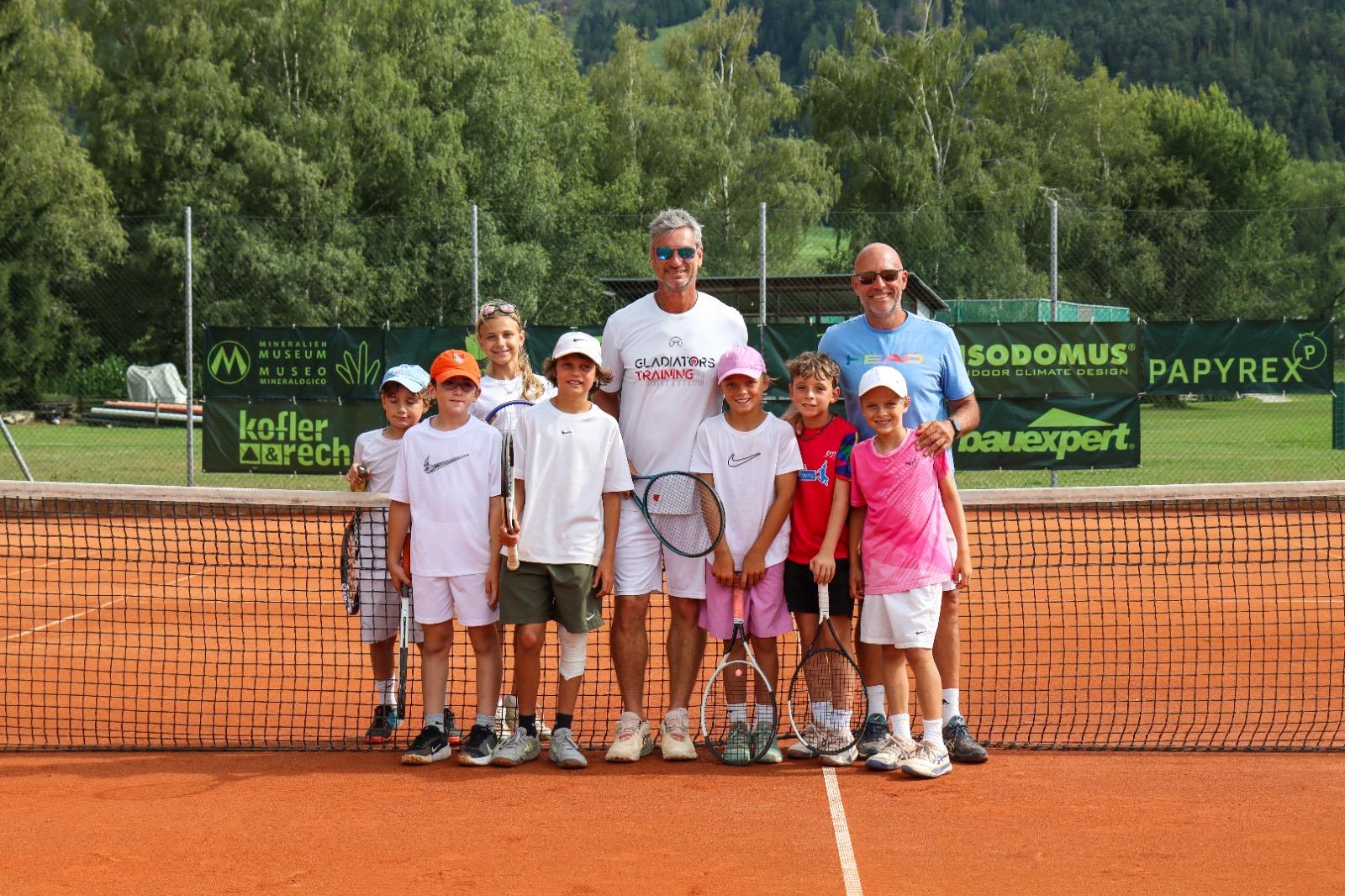 Lo staff Gladiators Training con un gruppo di giovani tennisti a bordo campo