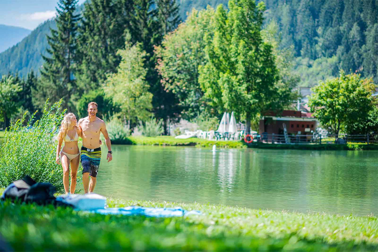 Hotel Montis – Ospiti in costume da bagno lungo un laghetto nel verde